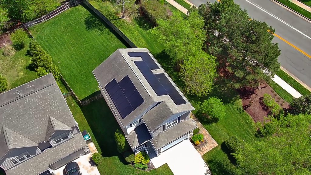 Aerial view of a home with a rooftop solar installation