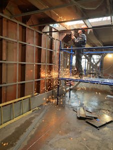 Welder working inside industrial building